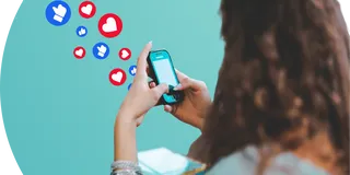 Like and Love icons flow from a cell phone in a woman's hand