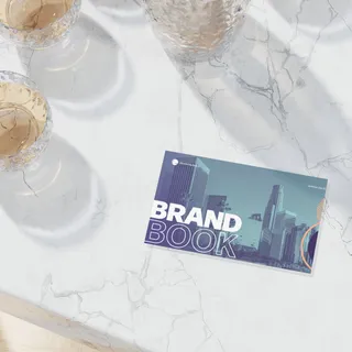 A green and purple brand book sits on a granite countertop