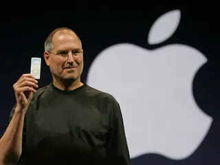 Steve Jobs presents an iPod in front of the Apple logo