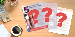 Three marketing education handouts site on a physical desktop