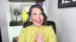 Woman in lime green shirt sits and waves at the camera
